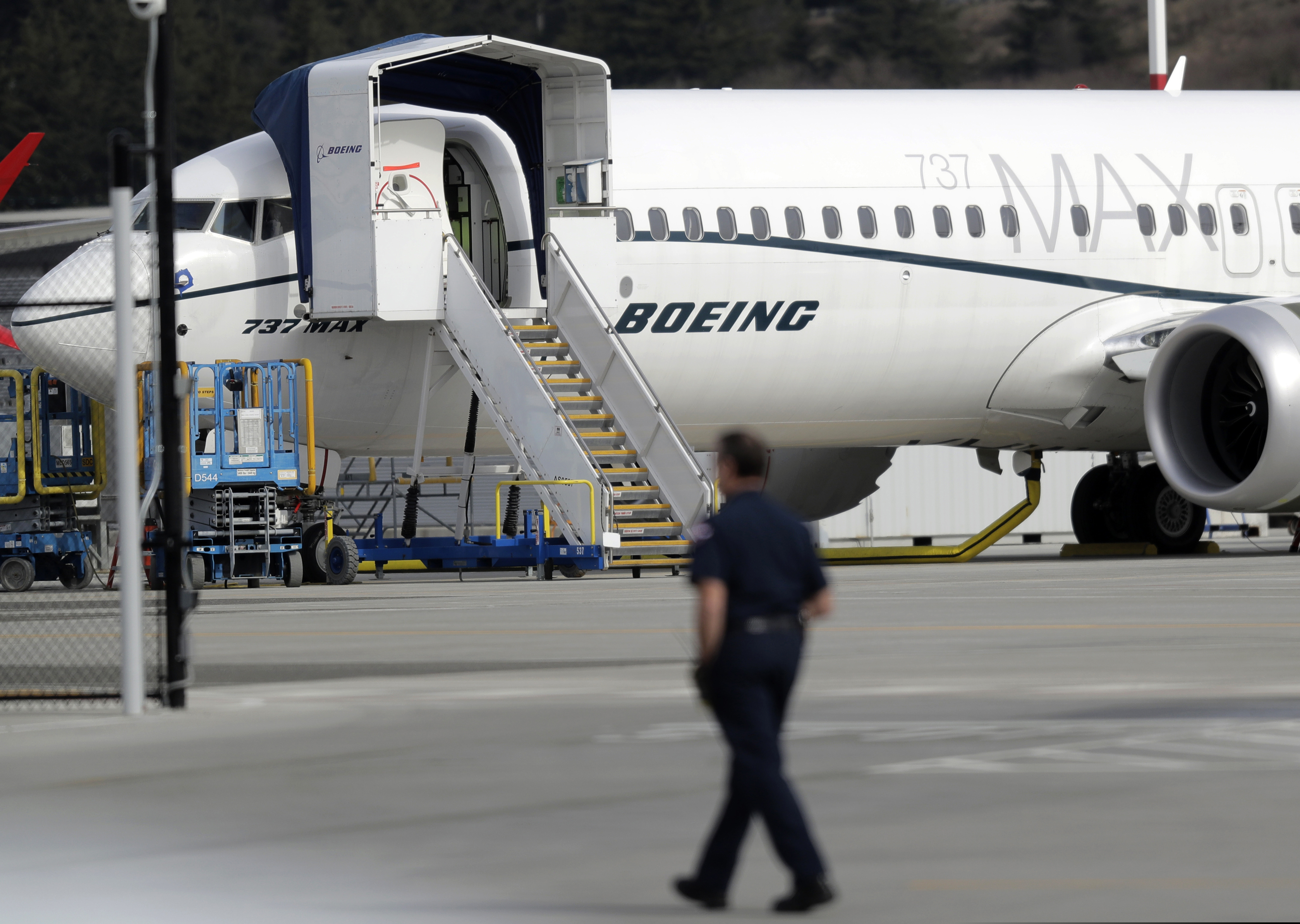 (Ted S. Warren | Associated Press file photo) A worker walks next to a Boeing 737 MAX 8 airplane parked at Boeing Field in Seattle. U.S. prosecutors are looking into the development of Boeing's 737 Max jets, a person briefed on the matter revealed Monday, the same day French aviation investigators concluded there were "clear similarities" in the crash of an Ethiopian Airlines Max 8 last week and a Lion Air jet in October.