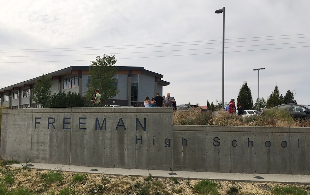 People gather outside of Freeman High School after reports of a shooting at the school in Rockford, Wash., Wednesday, Sept. 13, 2017. (KHQ via AP)