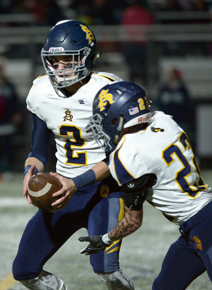 (Leah Hogsten | The Salt Lake Tribune) Summit Academy's quarterback Hayden Reynolds hands off to Mitch Hansen. Summit Academy boys' football team leads Juan Diego High School 51-35 during their game, October 13, 2017 in Draper.