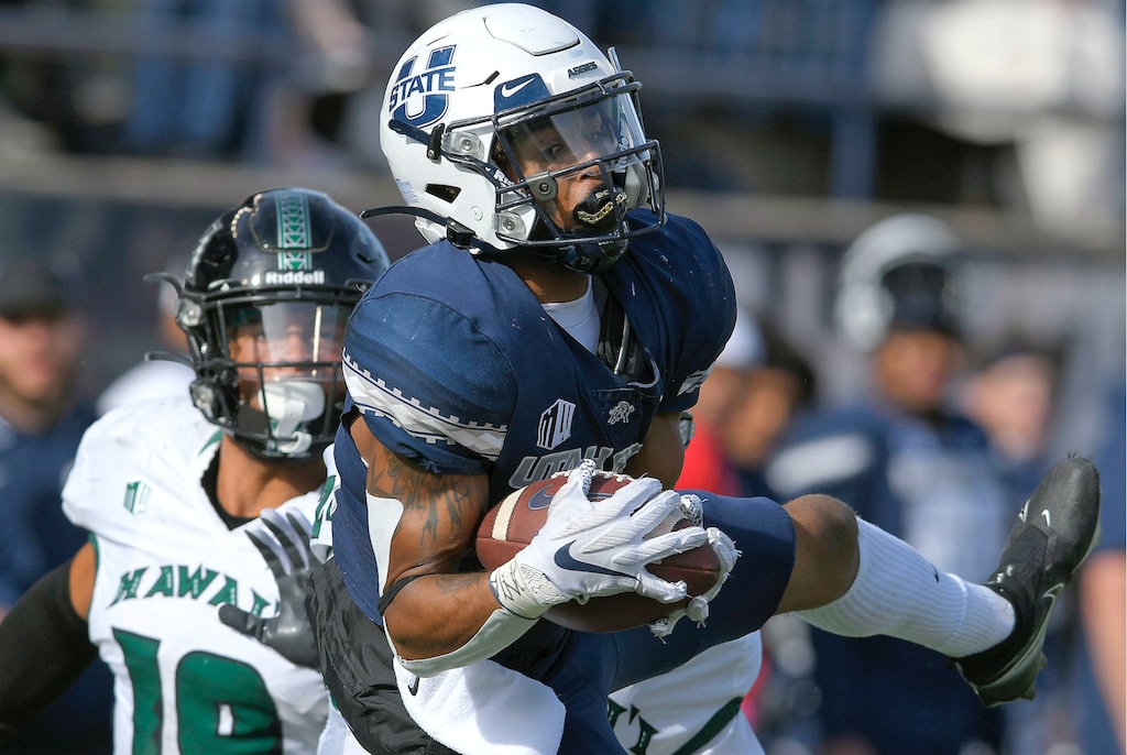 Utah State wide receiver Deven Thompkins (13) catches a pass as Hawaii defensive back Quentin Frazier (19) defends during the first half of an NCAA college football game Saturday, Oct. 30, 2021, in Logan, Utah. (Eli Lucero/The Herald Journal via AP)