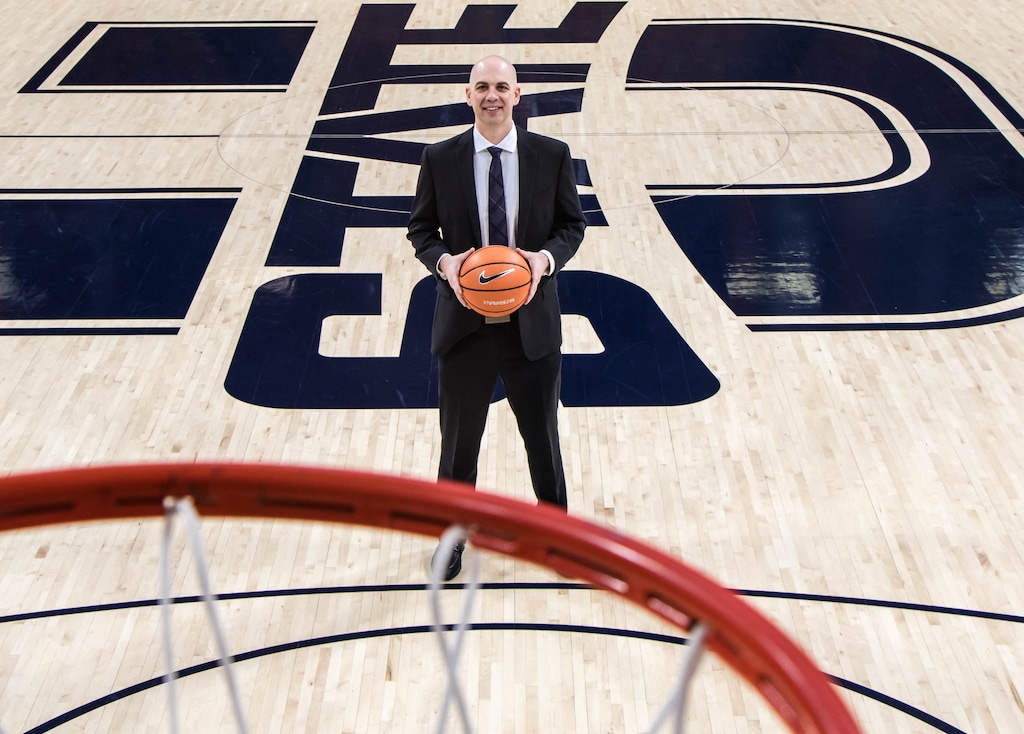 (Photo courtesy of USU athletics) Utah State men's basketball coach Craig Smith poses on the court inside the Dee Glen Smith Spectrum in Logan.