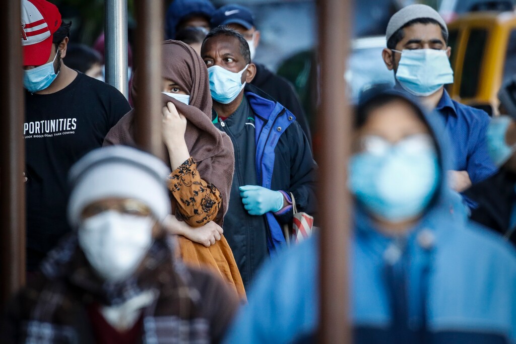 (John Minchillo | AP file photo) People wearing masks wait in line for food donations Wednesday, May 13, 2020, in the Brooklyn borough of New York, during the coronavirus pandemic.