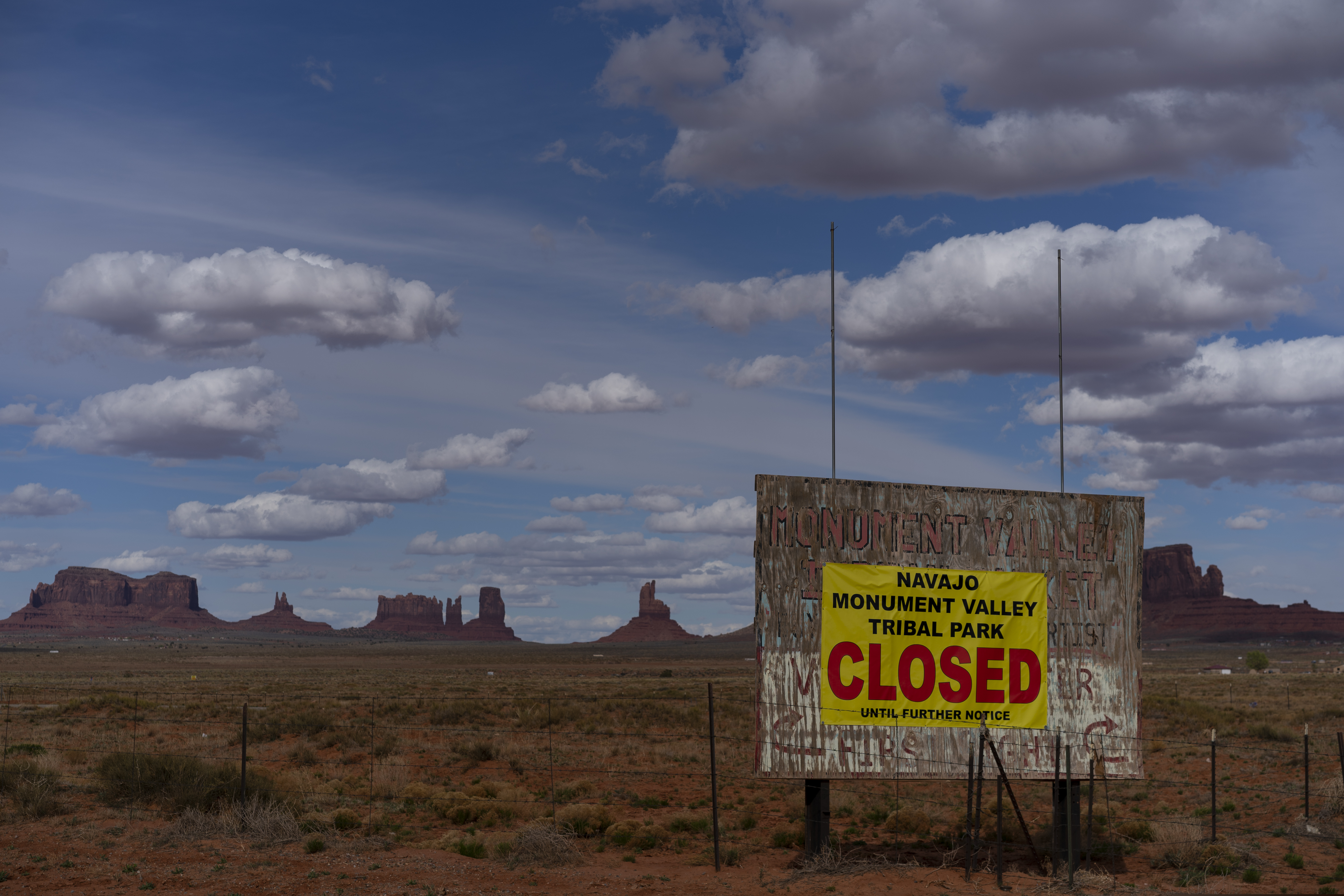 A sign reads "Navajo Monument Vally Tribal Park Closed Until Further Notice" posted at the entrance of Monument Valley in Oljato-Monument Valley, Utah, on the Navajo reservation April 19, 2020. The reservation has some of the highest rates of coronavirus in the country. If Navajos are susceptible to the virus' spread in part because they are so closely knit, that's also how many believe they will beat it. (AP Photo/Carolyn Kaster)