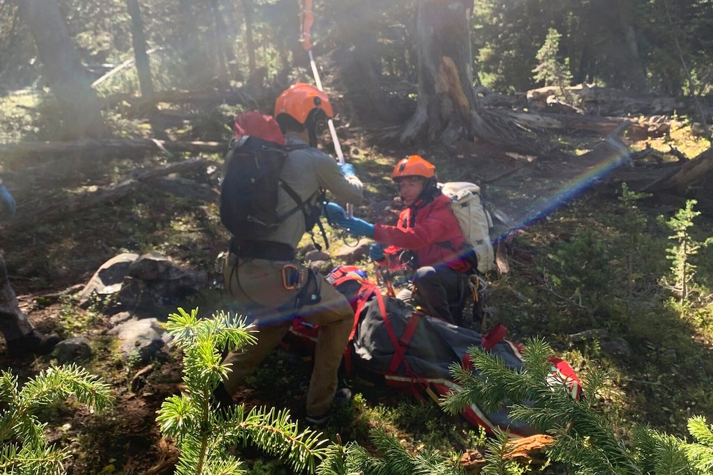 (Gallatin County Sheriff Search and Rescue via AP) In this photo provided by the Gallatin County, Mont., Sheriff Search and Rescue, members of the search and rescue team hook up rope hanging from a rescue helicopter to a basket holding Rudy Noorlander after Noorlander was mauled by a grizzly bear that bit off his lower jaw, Friday, Sept. 8, 2023. The attack happened in the Custer Gallatin National Forest about 55 miles north of Yellowstone National Park. Noorlander remained hospitalized, Monday, Sept. 11. His daughter said he's doing well, but is expected to be there through October for surgeries.