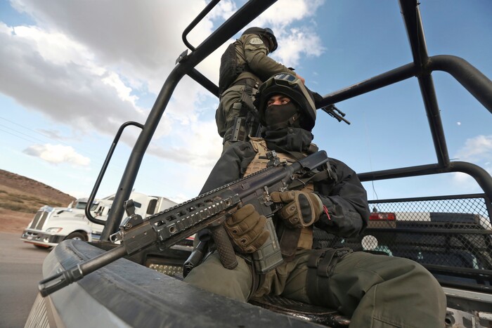 Chihuahua state police officers man a checkpoint in Janos, Chihuahua state, northern Mexico, Tuesday, Nov. 5, 2019. Drug cartel gunmen ambushed three SUVs along a dirt road, slaughtering six children and three women, all U.S. citizens living in northern Mexico, in a grisly attack that left one vehicle a burned-out, bullet-riddled hulk, authorities said Tuesday. (AP Photo/Christian Chavez)