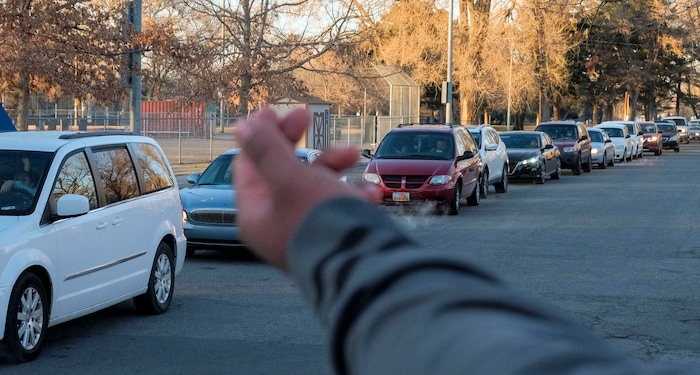 (Leah Hogsten | The Salt Lake Tribune) Volunteers hand out food from the Utah Food Bank to needy families, Dec. 23, 2020. One year ago, the Food Band was serving 75 families, but now they serve 325 families, said manager Kenneth Greenland. Cars begin lining up at 1pm for the 4:30pm start.