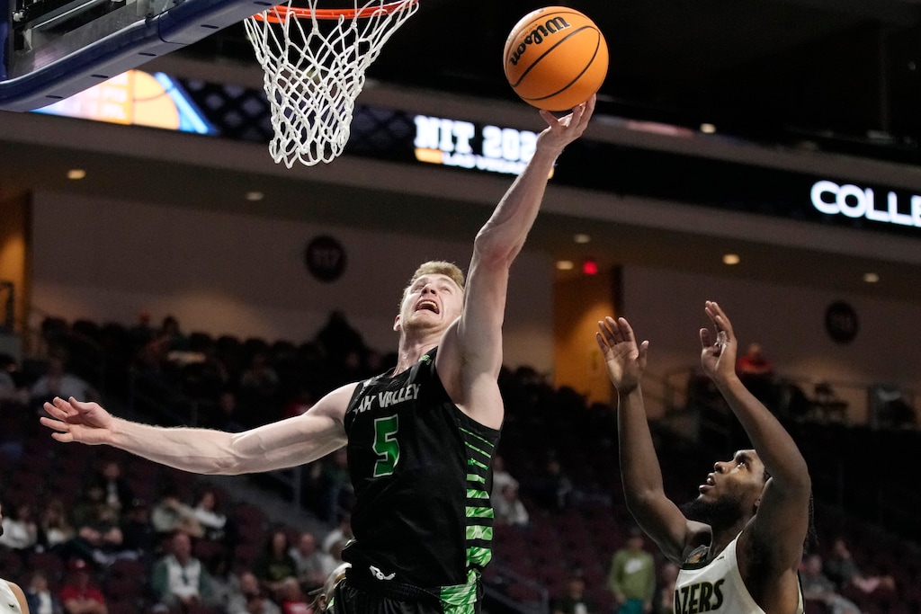 Utah Valley's Tim Fuller (5) shoots over UAB's Jordan Walker (10) during the second half of an NCAA college basketball game in the semifinals of the NIT, Tuesday, March 28, 2023, in Las Vegas. (AP Photo/John Locher)