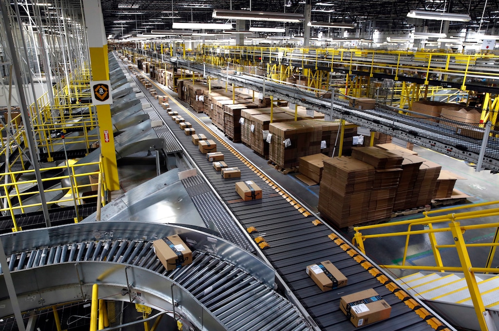 (Patrick Semansky | AP file photo) In this Aug. 3, 2017, file photo, packages ride on a conveyor system at an Amazon fulfillment center in Baltimore. Amazon, which is racing to deliver packages faster, is turning to its employees with a proposition: Quit your job and we’ll help you start a business delivering Amazon package. The offer, announced Monday, May 13, 2019, comes as Amazon seeks to speed up its shipping time from two days to one for its Prime members.