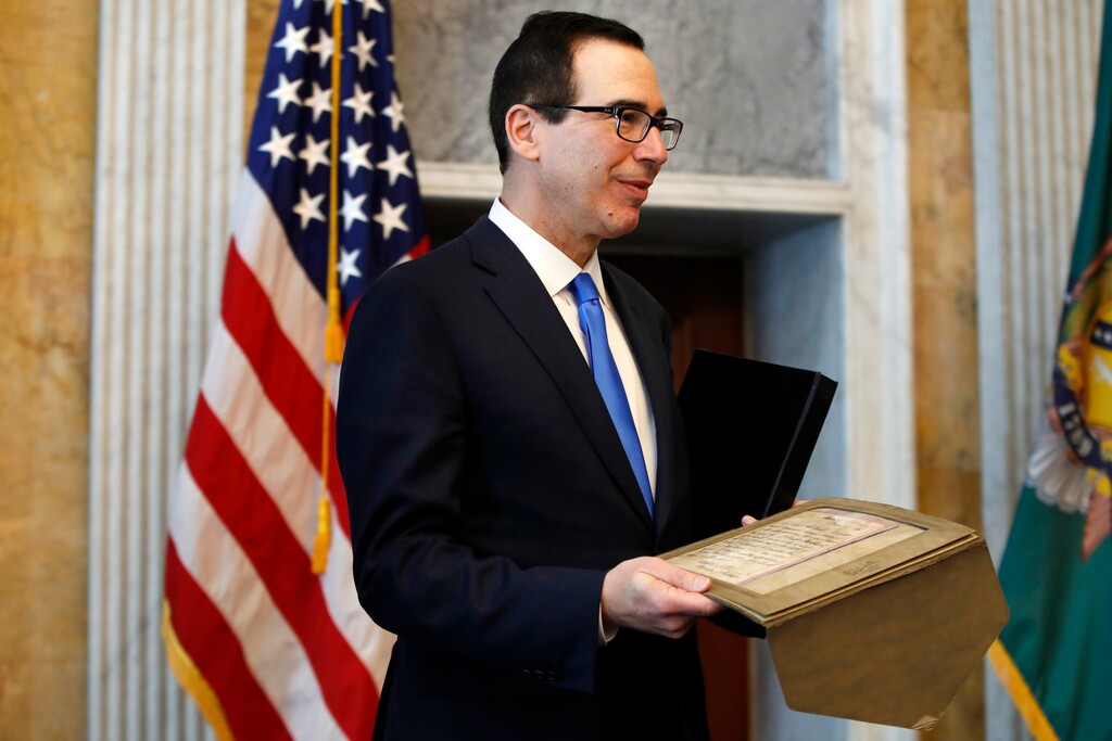 On behalf of the Treasury Department, Treasury Secretary Steven Mnuchin accepts a letter from 1861 written by 24th Treasury Secretary John Adams Dix, from the National Collector's Mint, during a ceremony at the Treasury, Wednesday, March 7, 2018. (AP Photo/Jacquelyn Martin)