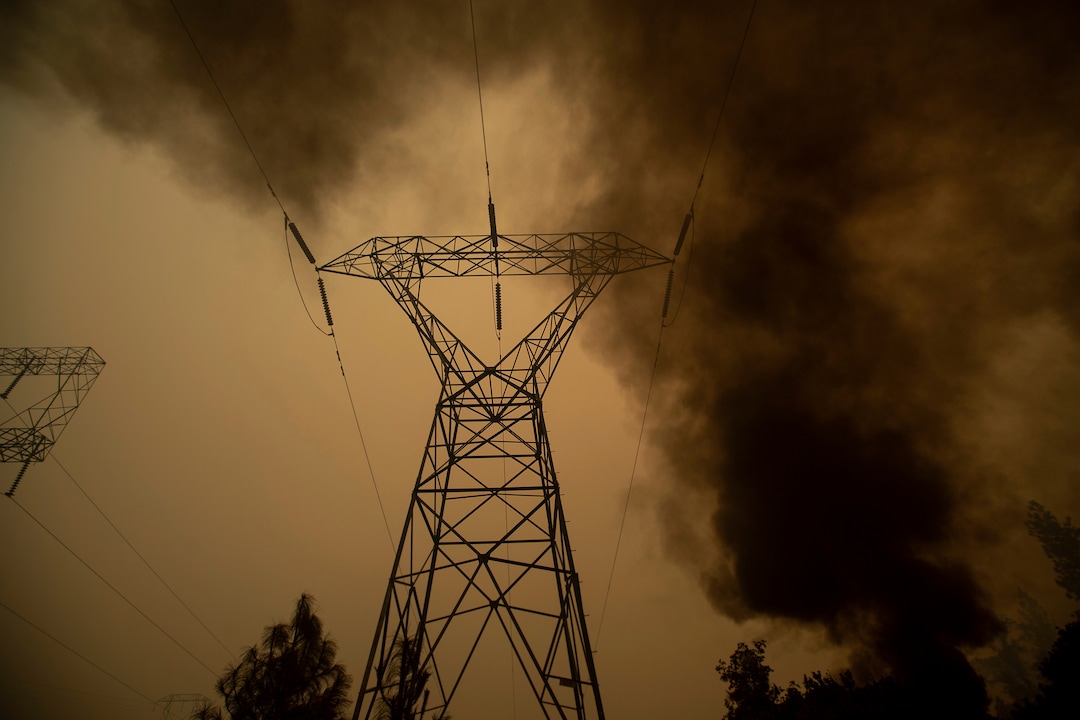 Smoke billows around power transmission lines as the Camp Fire burns in Big Bend, Calif., on Friday, Nov. 9, 2018. (AP Photo/Noah Berger)