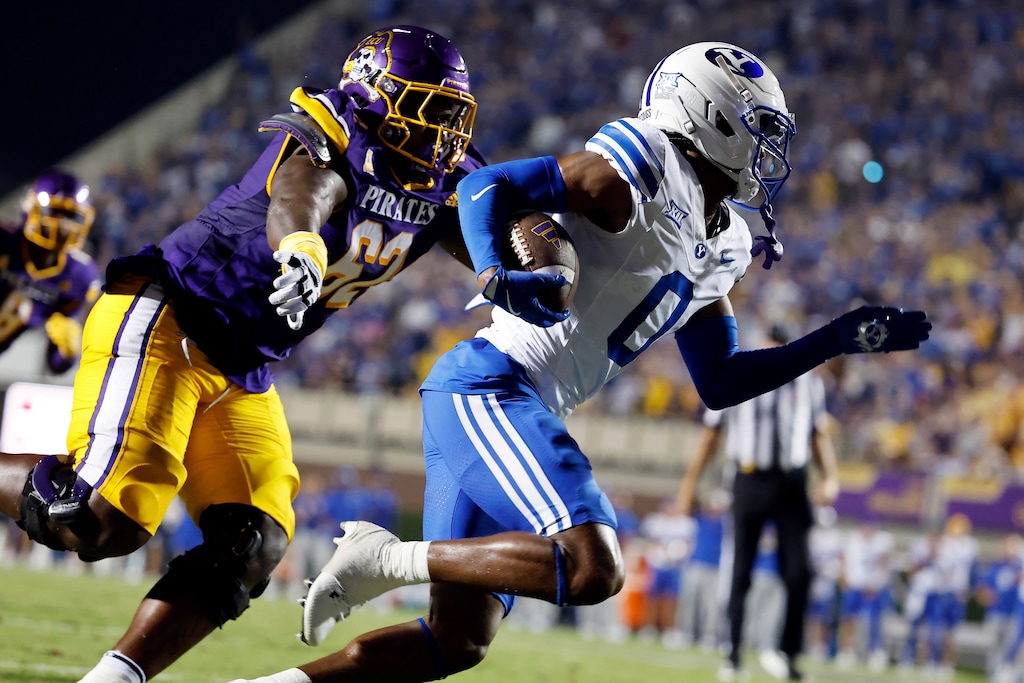 (Karl DeBlaker | AP) BYU's Evan Johnson (0) runs away from East Carolina offensive lineman Jimarion McCrimon (62) after intercepting a pass in Greenville, N.C., on Saturday, Sept. 20, 2025.