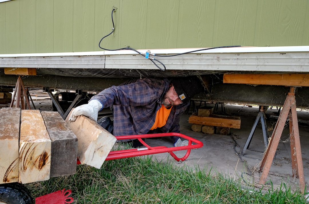 (Francisco Kjolseth  |  The Salt Lake Tribune) Antonio Tunno risks going under his home in the Western Estates mobile home park in Magna on Monday, March 23, 2020, for the first time since last week's earthquake despite feeling an aftershock earlier in the morning. Using wood blocks, Tunno was trying to shore up his home after multiple jacks under his home had failed, much like many of his surrounding neighbors.