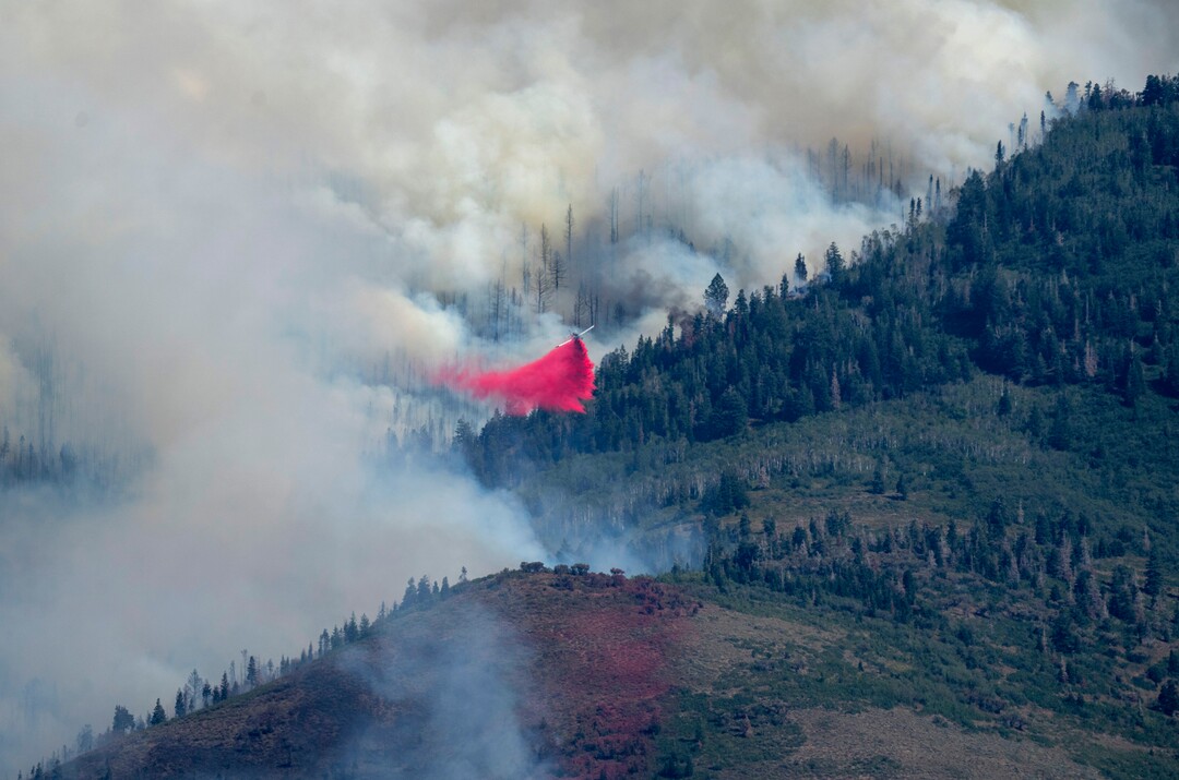 (Rick Egan | The Salt Lake Tribune) A plane drops fire retardant on the fire in Parley's Canyon, on Saturday, Aug. 14, 2021.