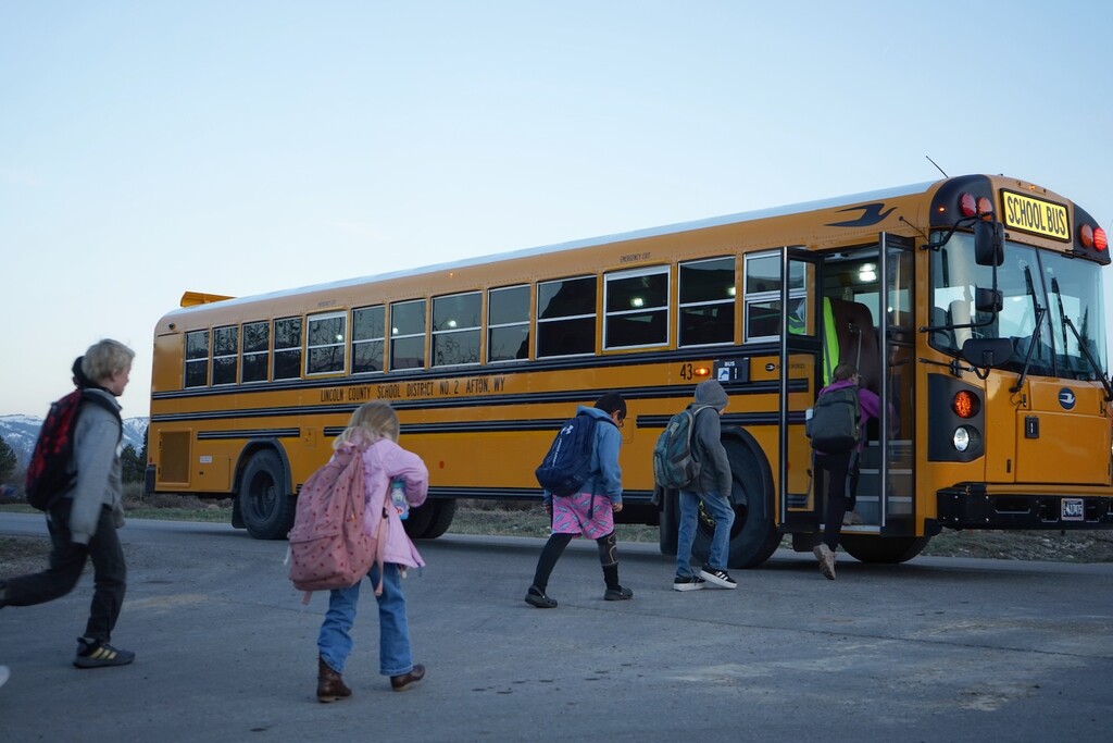 (Katie Klingsporn | WyoFile)
Alpine children climb into a Lincoln County District 2 school bus en route to schools located south in Star Valley on April 11, 2025.