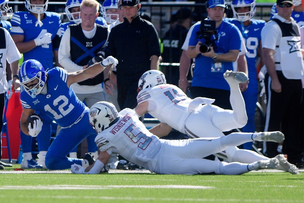 (Annie Rice | AP) BYU running back Preston Rex (12) is tackled by Texas Tech's Cole Wisniewski (5) during the first half of a game against Texas Tech, Saturday, Nov. 8, 2025, in Lubbock, Texas.