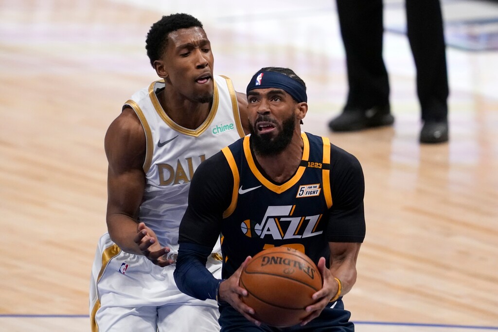 Utah Jazz guard Mike Conley, right, drives past Dallas Mavericks guard Josh Richardson, left, to the basket for a shot in the first half of an NBA basketball game in Dallas, Monday, April 5, 2021. (AP Photo/Tony Gutierrez)