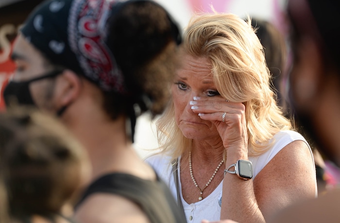 (Francisco Kjolseth  |  The Salt Lake Tribune) Cindy Moss, who’s nephew Darrien Hunt was killed by police in 2014, joins a vigil organized by family of Dillon Taylor on the six-year anniversary of his death by cop at the murals of those people killed by police near 800 South and 300 West in Salt Lake City on Tuesday, August 11, 2020. Multiple families who’s loved one’s are depicted on the walls joined the vigil as they moved from portrait to portrait to remember them.