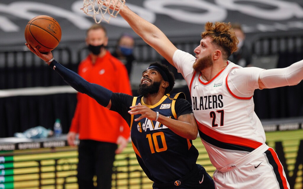 Utah Jazz guard Mike Conley, left, shoots as Portland Trail Blazers center Jusuf Nurkic defends during the first half of an NBA basketball game in Portland, Ore., Wednesday, Dec. 23, 2020. (AP Photo/Steve Dipaola)