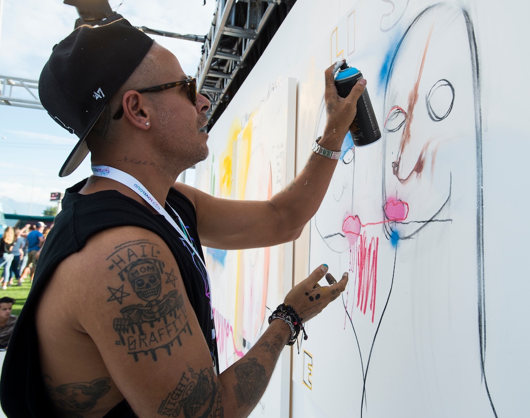(Rick Egan  |  The Salt Lake Tribune)  Los Angeles artist Louis Carreon, works on four canvases that will be auctioned off later in the evening at the LoveLoud Festival at Brent Brown Ballpark at UVU campus, Saturday, August 26, 2017.