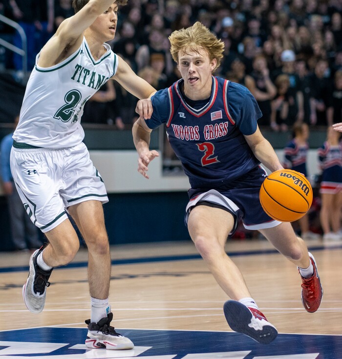 (Rick Egan | The Salt Lake Tribune) 
Woods Cross guard, Zach Delange (2) goes to the hoop, as Olympus Titan Olympus forward, Lucas McKane (22) defends, in the 5A State Championship game between Woods Cross and Olympus, at the Marriott Center in Provo, on Saturday, March 5, 2022.