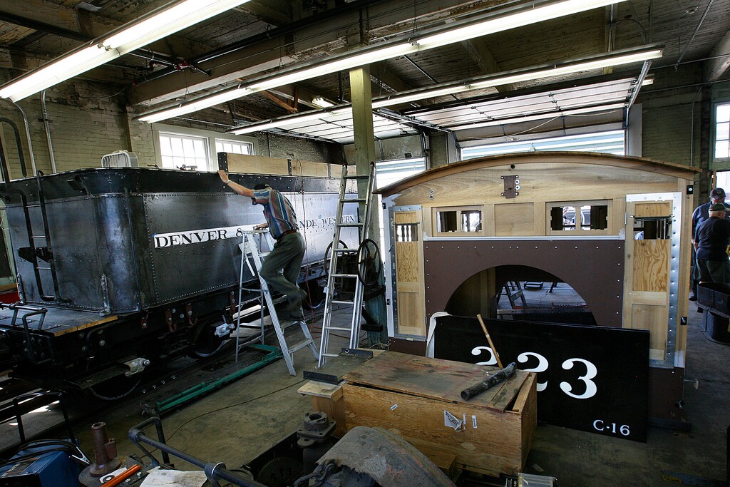 (Scott Sommerdorf | Tribune file photo) In this 2012 file photo, Maynard Morris climbs a ladder to get a look at the progress being made on the tender car for an engine that a group of volunteers in Ogden comes together every Saturday to work on. They were restoring a narrow gauge locomotive at the Union Station Trainmen's Building.