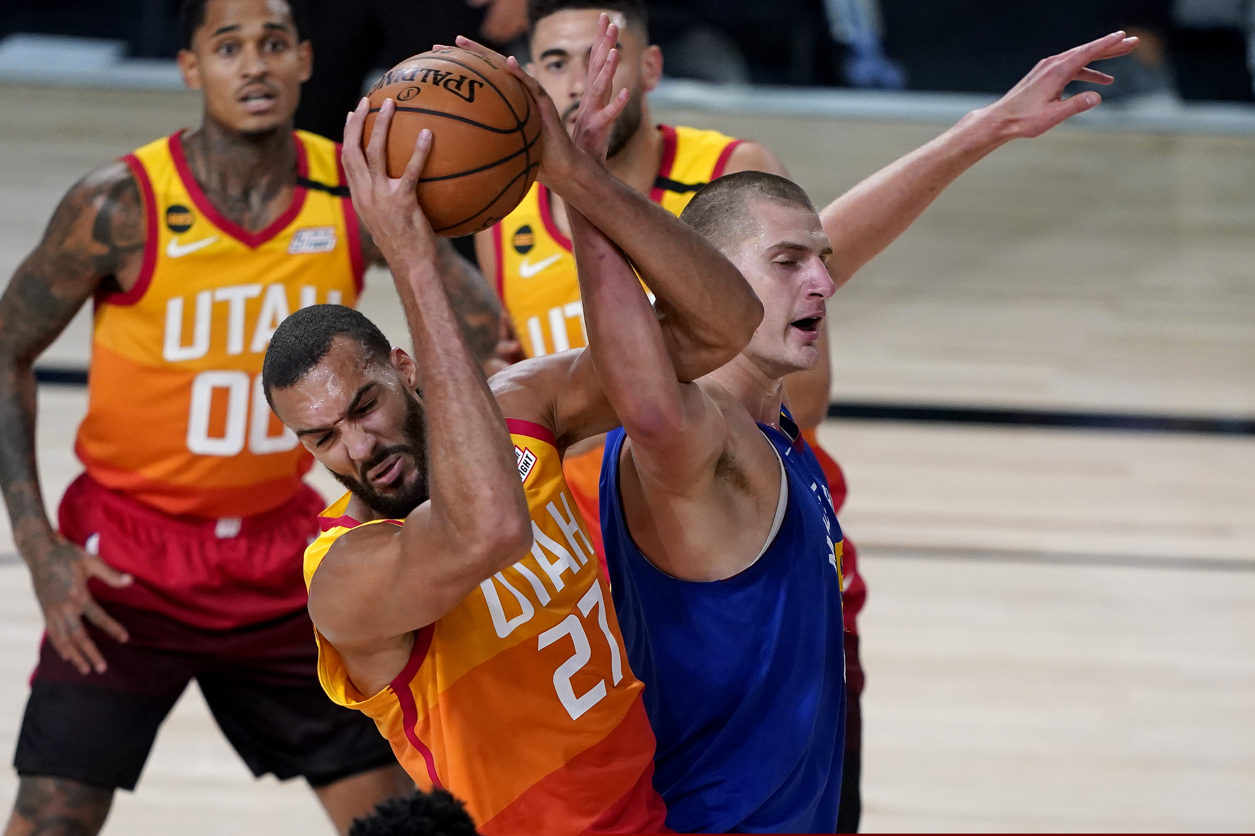 Utah Jazz's Rudy Gobert (27) battles Denver Nuggets' Nikola Jokic for the rebound during the first half of an NBA basketball first round playoff game Friday, Aug. 21, 2020, in Lake Buena Vista, Fla. (AP Photo/Ashley Landis, Pool)