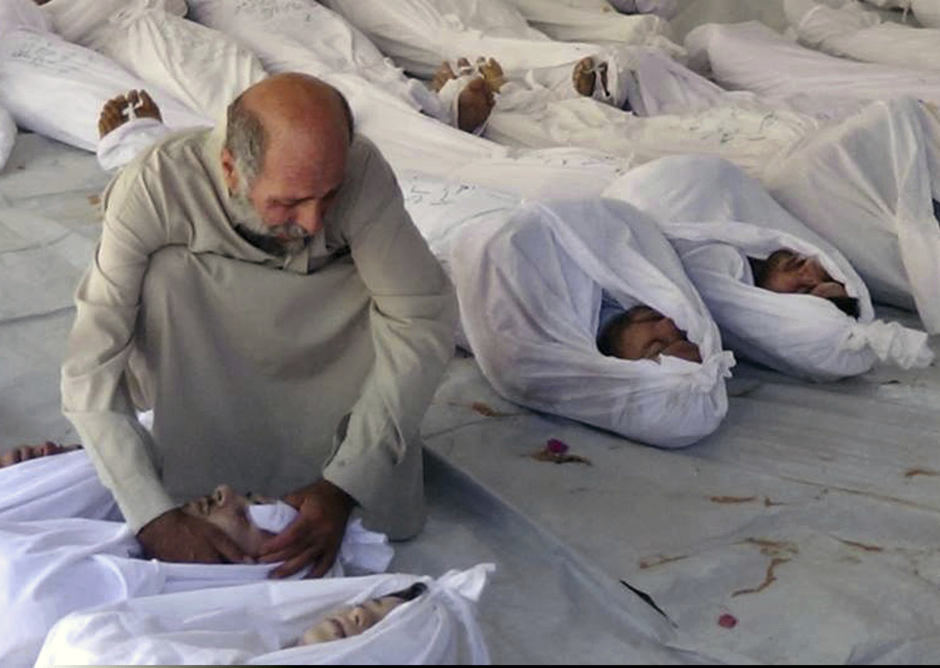 (AP Photo/Media Office Of Douma City, File) This Aug. 21, 2013 file citizen journalism image provided by the anti-government Media Office Of Douma City which has been authenticated based on its contents and other AP reporting, shows a Syrian man mourning over a dead body after an alleged poisonous gas attack fired by government forces, according to activists, in Douma town, Damascus, Syria. A spokesman for the U.S.-led coalition said Friday, Jan. 11, 2019 that the process of withdrawal in Syria has begun, declining to comment on specific timetables or movements.
