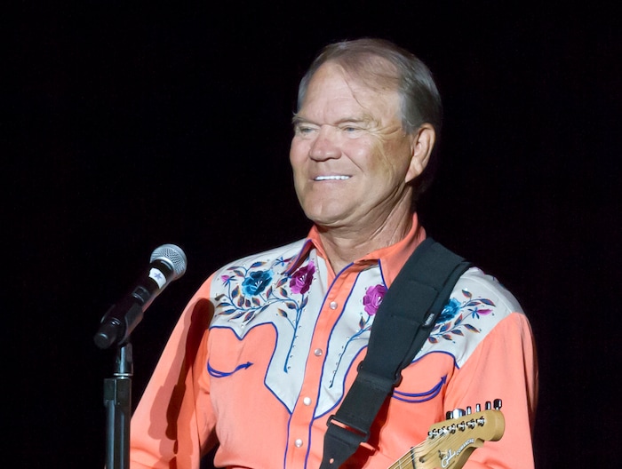 FILE - This Sept. 6, 2012 file photo shows singer Glen Campbell performing during his Goodbye Tour in Little Rock, Ark. Campbell, the grinning, high-pitched entertainer who had such hits as "Rhinestone Cowboy" and spanned country, pop, television and movies, died Tuesday, Aug. 8, 2017. He was 81. Campbell announced in June 2011 that he had been diagnosed with Alzheimer's disease. (AP Photo/Danny Johnston, File)