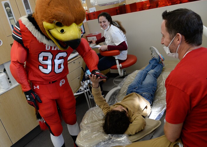 (Francisco Kjolseth  |  The Salt Lake Tribune) Swoop the mascot gets a high five from a young patient before getting free dental care during an outreach program at the University of Utah on Saturday, Feb. 29, 2020, as part of the American Dental AssociationÕs ÒGive Kids a SmileÓ program to help the underserved young.