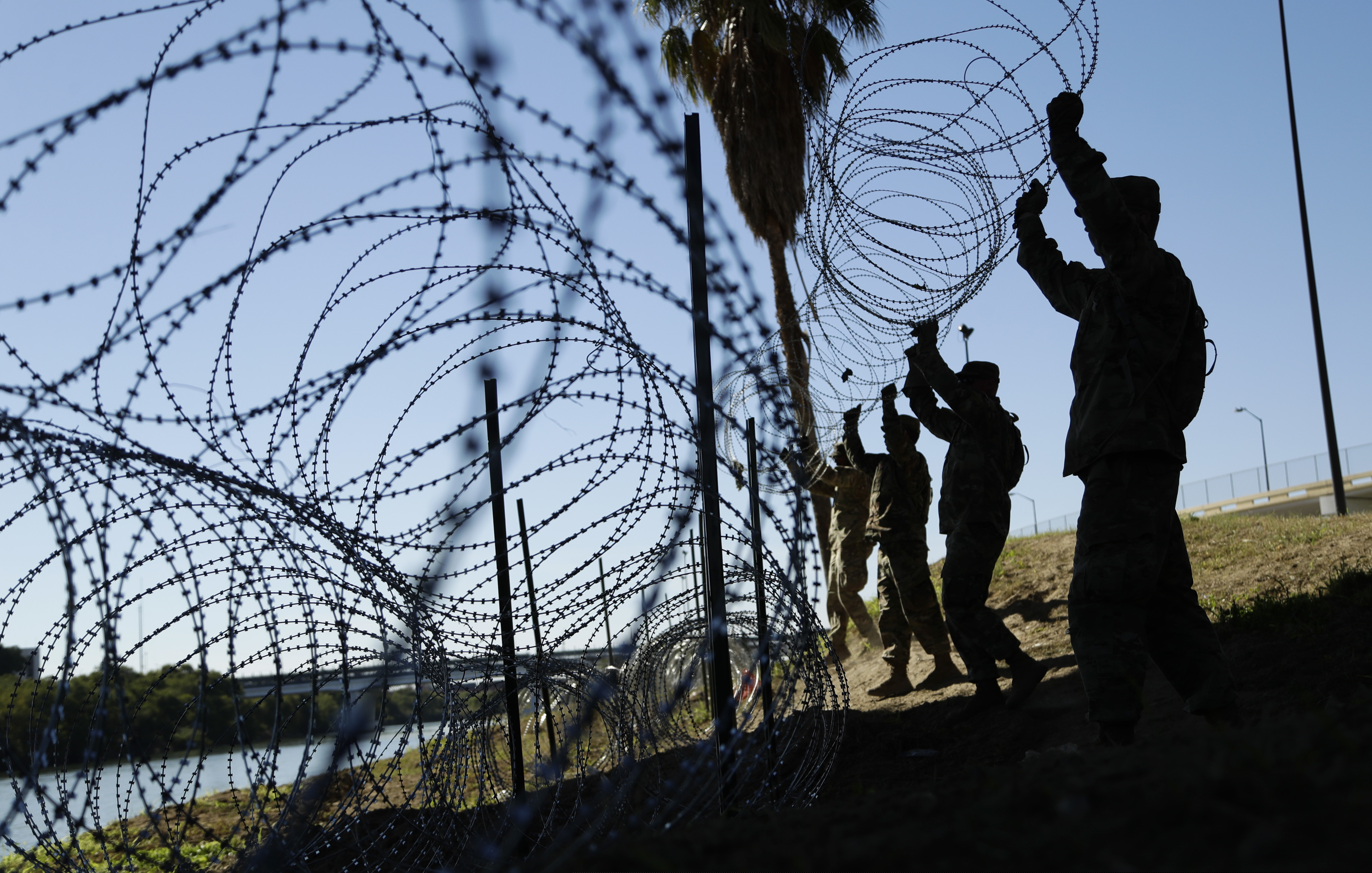 (Eric Gay | The Associated Press) In this Friday, Nov. 16, 2018, file photo, members of the U.S. military install multiple tiers of concertina wire along the banks of the Rio Grande near the Juarez-Lincoln Bridge at the U.S.-Mexico border, in Laredo, Texas. The Pentagon said Sunday, Feb. 3, 2019, it will send 3,750 more troops to the U.S.-Mexico border to put up another 150 miles of concertina wire and provide other support for Customs and Border Protection.