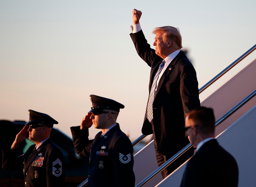 (Carolyn Kaster | The Associated Press) President Donald Trump gestures to people cheering him across the tarmac as he, arrives on Air Force One with first lady Melania Trump and their son Barron Trump at Palm Beach International Airport, in West Palm Beach, Fla., Friday, March 23, 2018. Trump is issuing an order to ban transgender people from serving in the military except under "limited circumstances," following up on his calls to ban transgender individuals from serving.