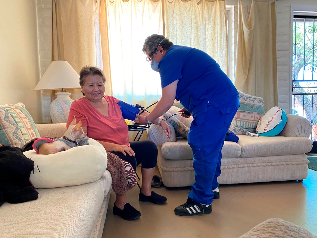 (Shannon Todecheene via AP) In this May 15, 2020 photo provided by Shannon Todecheene, her mother, Carol Todecheene, left, receives therapy services at her daughter's home in Tucson, Ariz. Carol Todecheene was among those severely hit with the coronavirus.