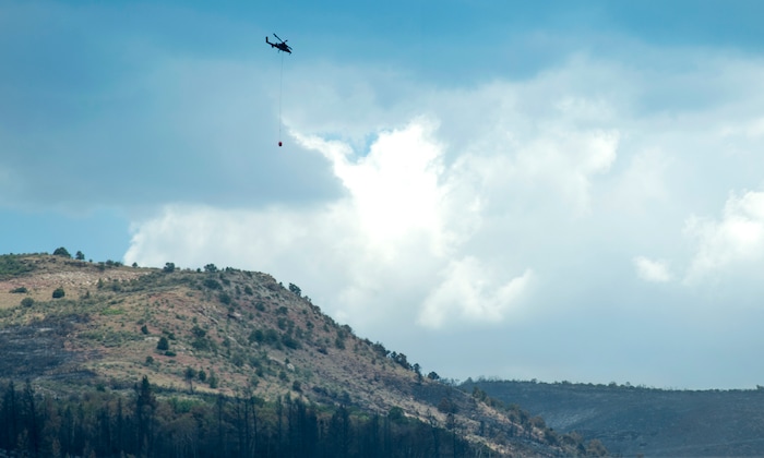 (Rick Egan  |  The Salt Lake Tribune)       A helicopter carries water for the Dollar Ridge Fire, Tuesday, July 10, 2018.


