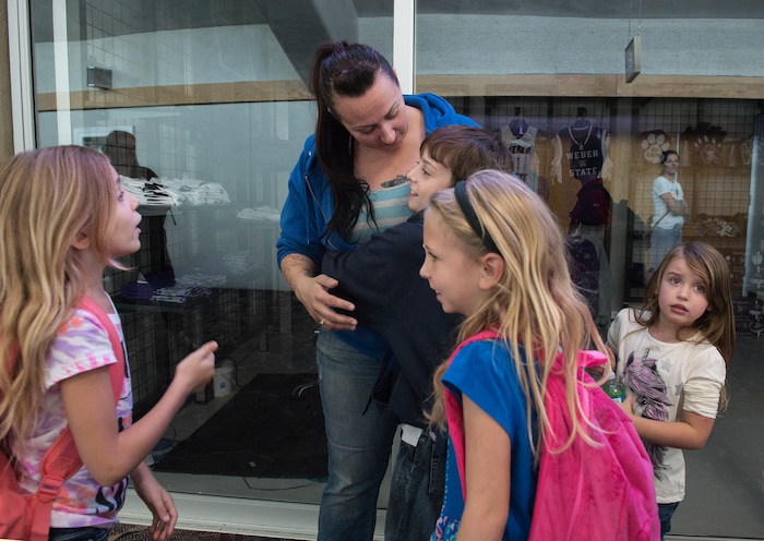 (Leah Hogsten  |  The Salt Lake Tribune) Casey New (center) receives hugs from her children l-r Brooklyn, Kenny, Kia and Spenzir, who are students at Uintah Elementary School who were evacuated to the Dee Events Center on the Weber State University campus in Ogden, Tuesday September 5, 2017.  The Uintah Fire is still burning through the town of Uintah and pockets of South Weber, as well as the unincorporated subdivision of Uintah Highlands.
