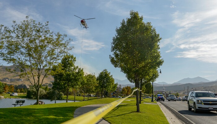 Leah Hogsten  |  The Salt Lake Tribune   A firefighting helicopter refills with water near Herriman Cove pond. A 50-acre wildfire in Rose Canyon was threatened about a half-dozen homes Wednesday, Sept. 12, 2018. A spokesman for Unified Fire said the blaze has already burned a few structures, including outhouses and sheds. Firefighters have evacuated around 20 to 30 homes in two neighborhoods near 15555 S. Rose Canyon Road in Herriman. 