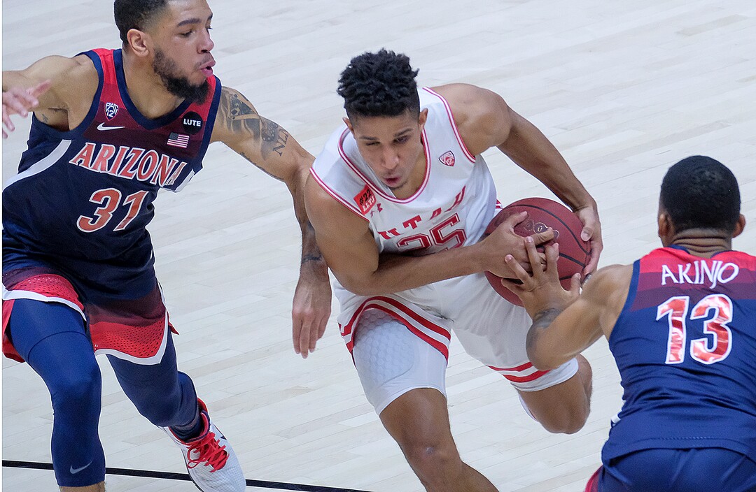 (Leah Hogsten | The Salt Lake Tribune) Utah Utes guard Alfonso Plummer (25) drives through Arizona Wildcats guard Terrell Brown Jr. (31) and Arizona Wildcats guard James Akinjo (13) as the University of Utah host the Arizona Wildcats, Feb. 4, 2021 at the Jon M. Huntsman Arena.