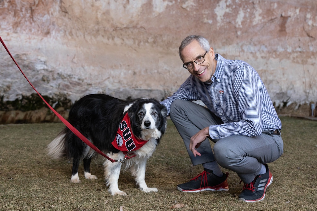 (Photo courtesy of Southern Utah University) SUU President Scott Wyatt pets a dog after announcing a new partnership with Best Friends Animal Society on Tuesday, Dec. 10, 2019. Wyatt announced this week that he will be stepping down from his position in August 2021.