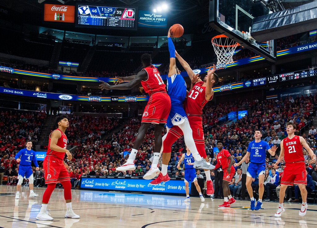 (Rick Egan  |  The Salt Lake Tribune)   Brigham Young Cougars forward Yoeli Childs (23) goes in for a slam-dunk as Utah Utes forward Both Gach (11) and Utah Utes forward Novak Topalovic (13) defend, in basketball action in the Beehive Classic, between against the Brigham Young Cougars and Utah Utes, a the Vivint Smart Home Arena, Saturday December 8, 2018.