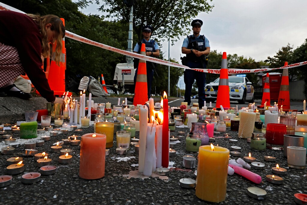 (Vincent Yu | The Associated Press) In this March 18, 2019, file photo, a student lights candle during a vigil to commemorate victims of March 15 shooting, outside the Al Noor mosque in Christchurch, New Zealand. New Zealanders are debating the limits of free speech after their chief censor banned a 74-page manifesto written by a man accused of massacring 50 people at two mosques.