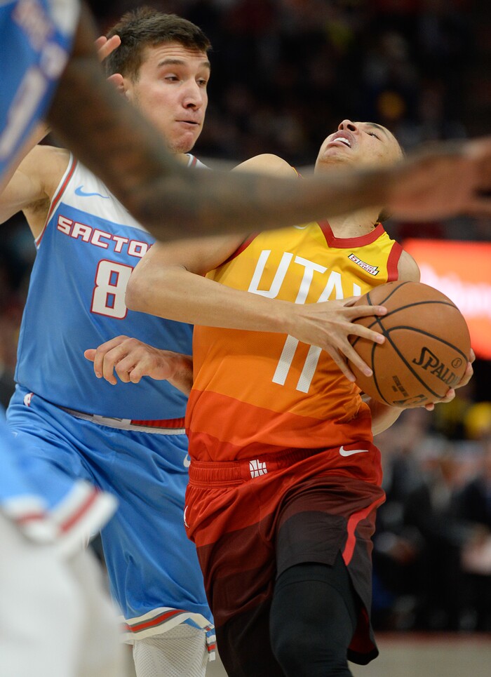 (Francisco Kjolseth  |  The Salt Lake Tribune)  Utah Jazz guard Dante Exum (11) is fouled by Sacramento Kings guard Bogdan Bogdanovic (8) on his way to the basket in the NBA game at Vivint Smart Home Arena Wed., Nov. 21, 2018, in Salt Lake City.
