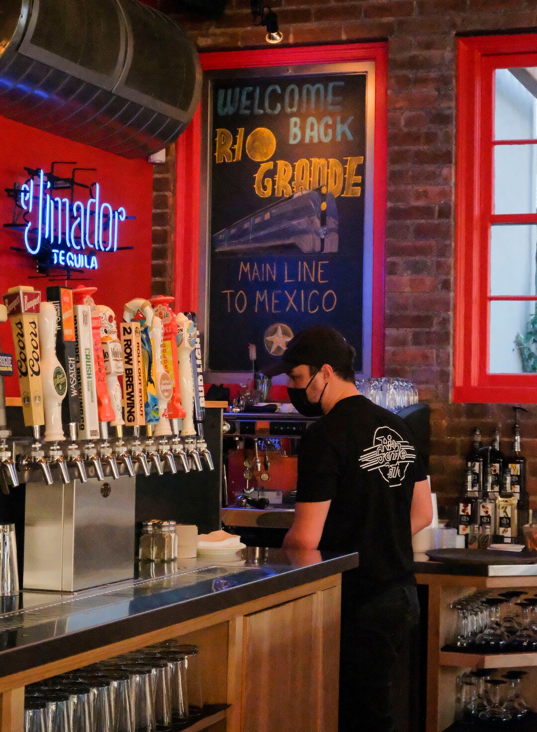 (Leah Hogsten  |  The Salt Lake Tribune) Rio Grande Cafe bartender Connor Preece pours drinks on Tuesday. Salt Lake City's popular Rio Grande Cafe, which has been closed since March due to the pandemic and the earthquake, has moved to its new location near the University of Utah on 1300 East, Dec. 29, 2020.