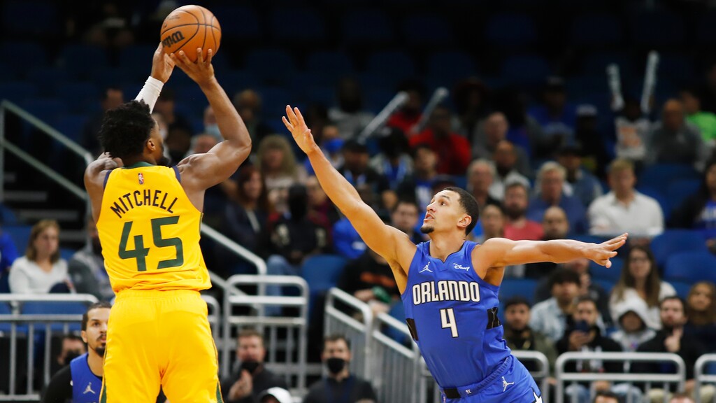 Orlando Magic guard Jalen Suggs (4) defends against a shot by Utah Jazz guard Donovan Mitchell (45) during the first half of an NBA basketball game, Sunday, Nov. 7, 2021, in Orlando, Fla. (AP Photo/Jacob M. Langston)