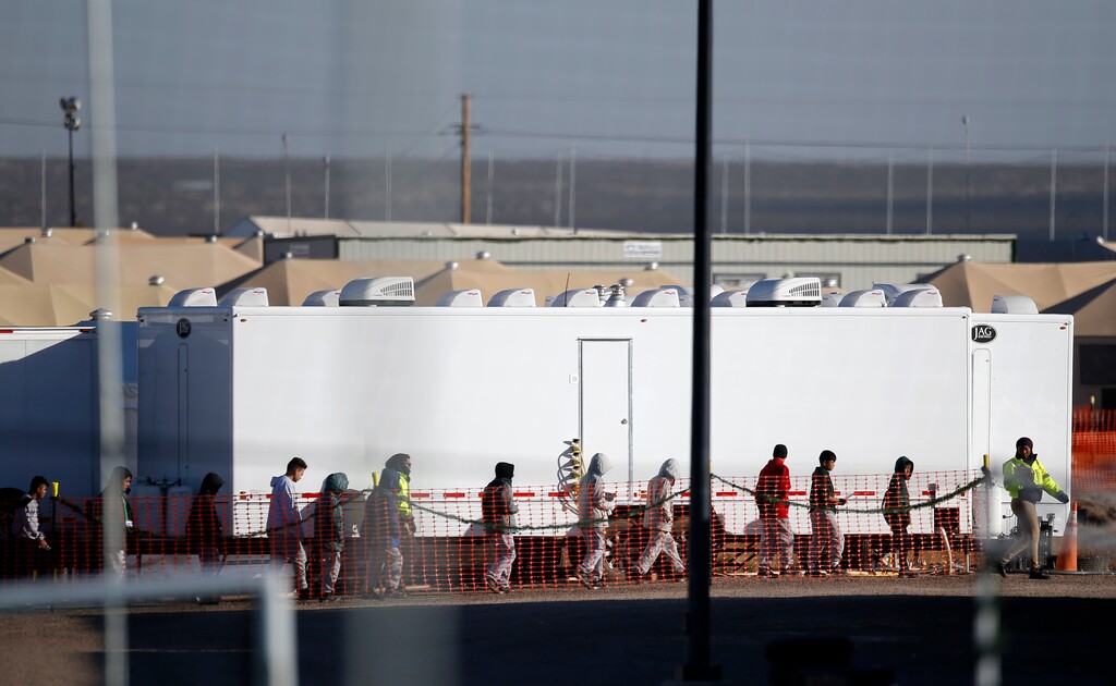 Migrant teens walk in a line through the Tornillo detention camp in Tornillo, Texas, Thursday, Dec. 13, 2018. The Trump administration announced in June 2018 that it would open the temporary shelter for up to 360 migrant children in this isolated corner of the Texas desert. Six months later, the facility has expanded into a detention camp holding thousands of teenagers. (AP Photo/Andres Leighton)