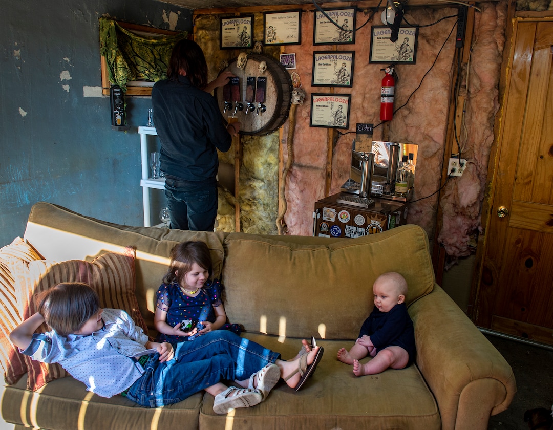 (Leah Hogsten  |  The Salt Lake Tribune)  Landon Jeffery pours himself one of his homebrewed beers while his children Xander, 7, Vivienne, 4, and Byron, 5mos., play on the couch, Sept. 12, 2019. Jeffery listed his children as co-brewers on his contest entries in the 2019 Beehive Brewoff where he was named Utah's "Best Home BrewerÓ. Jeffery earned five gold medals, three silver and a bronze, including the "best beer." The win is good news for Ogden beer drinkers Ñ as Jeffery will become a co-brewer at Ogden River Brewing, when it opens early next year.