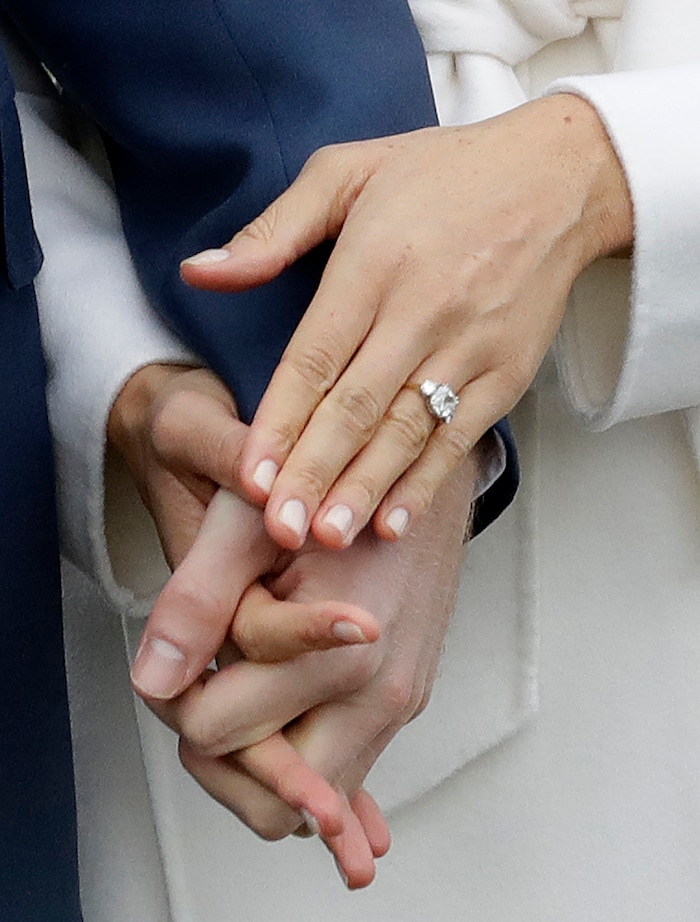 Britain's Prince Harry and his fiancee Meghan Markle hold hands as they pose for photographers during a photocall in the grounds of Kensington Palace in London, Monday Nov. 27, 2017. Britain's royal palace says Prince Harry and actress Meghan Markle are engaged and will marry in the spring of 2018. (AP Photo/Matt Dunham)