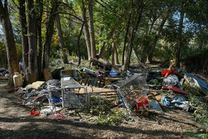 (Francisco Kjolseth  |  The Salt Lake Tribune)  Personal belongings at a former homeless camp along the Jordan River in Salt Lake are piled up after being taken down. Members of the Volunteers of America and One Voice Recovery were visiting known camps to offer their services to the transient community. 