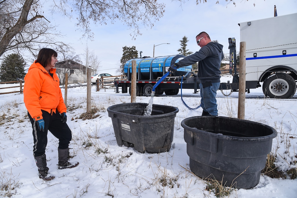 (Francisco Kjolseth  |  The Salt Lake Tribune)  Horse owner Kay Freeman has water containers filled with potable water on Sunday, Feb. 17, 2019, by Jason Hunt with Sandy City after finding out that her horses could also be affected by high levels of lead and copper in the water. The city says the problem started about Feb. 6, when a fluoride pump malfunctioned because of a power outage. It flooded the water system with fluoride and that also led to high levels of lead and copper, enough that it made some people sick.