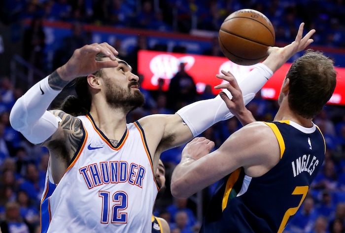 Oklahoma City Thunder center Steven Adams (12) reaches for a rebound with Utah Jazz forward Joe Ingles (2) in the first half of Game 1 of an NBA basketball first-round playoff series in Oklahoma City, Sunday, April 15, 2018. (AP Photo/Sue Ogrocki)