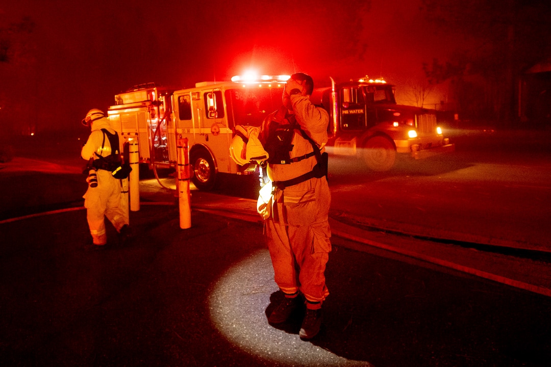 (Noah Berger | The Associated Press) Firefighter Adrien Mahnke pauses while battling the Camp Fire as it tears through Paradise, Calif., on Thursday, Nov. 8, 2018. Tens of thousands of people fled a fast-moving wildfire Thursday in Northern California, some clutching babies and pets as they abandoned vehicles and struck out on foot ahead of the flames that forced the evacuation of an entire town and destroyed hundreds of structures.