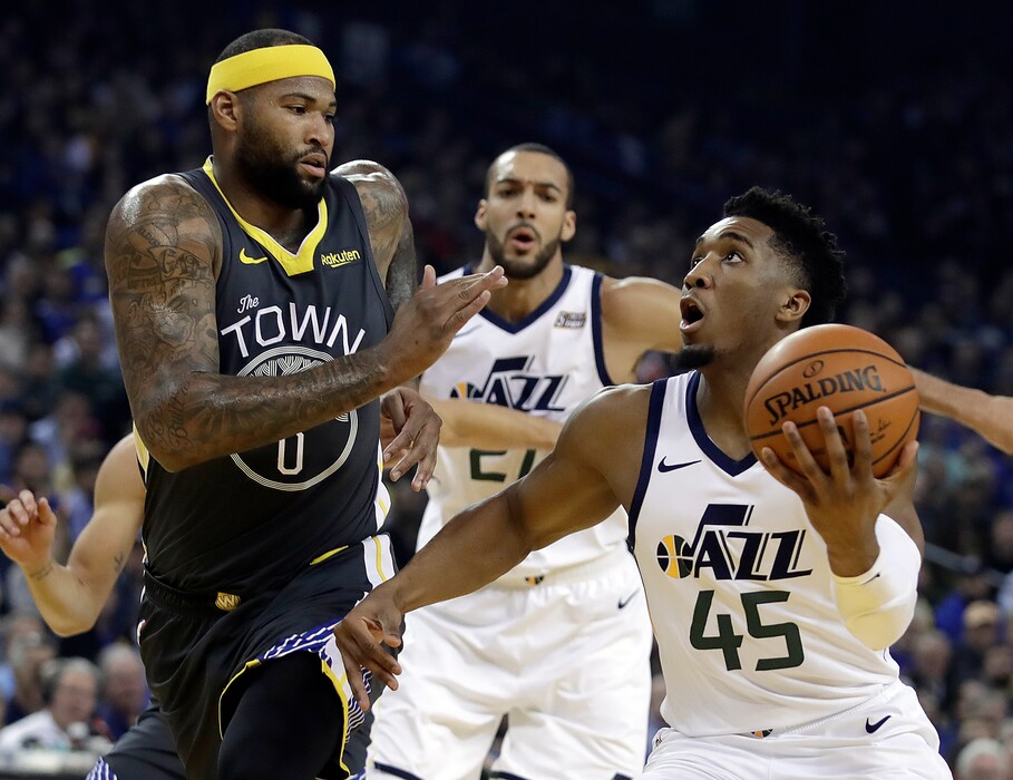 Utah Jazz guard Donovan Mitchell, right, looks to shoot against Golden State Warriors' DeMarcus Cousins (0) during the first half of an NBA basketball game, Tuesday, Feb. 12, 2019, in Oakland, Calif. (AP Photo/Ben Margot)